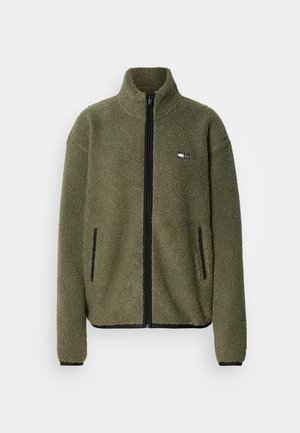 Fleecejakke i olivengrønn med høy krage, hel frontglidelås, svarte detaljer og to sidelommer. Mykt, teksturert stoff.