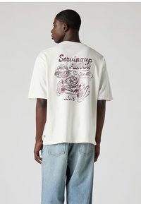 Λευκό βαμβακερό t-shirt με κοντά μανίκια, που διαθέτει πολύχρωμο γραφικό σχέδιο στην πλάτη με κείμενο και χαρακτήρα φαγητού.