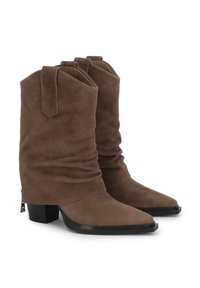 Botas de tobillo de ante marrón con un diseño holgado, punta afilada y tacón ancho. Presentan una suela negra y un detalle de cremallera en la parte trasera para facilitar su uso.