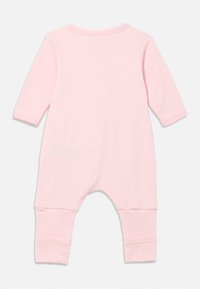 Ροζ ολόσωμη φόρμα από μαλακό ύφασμα, με μακριά μανίκια, ελαστική λαιμόκοψη και ριμπ μανσέτες για άνεση και καλή εφαρμογή.