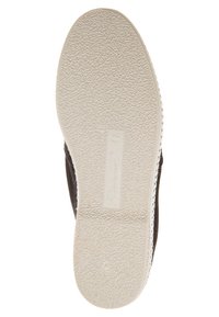 Onderkantzicht van een zwarte schoen met een gestructureerde witte rubberen zool, heeft een glad bovenmateriaal en minimale stikdetails.