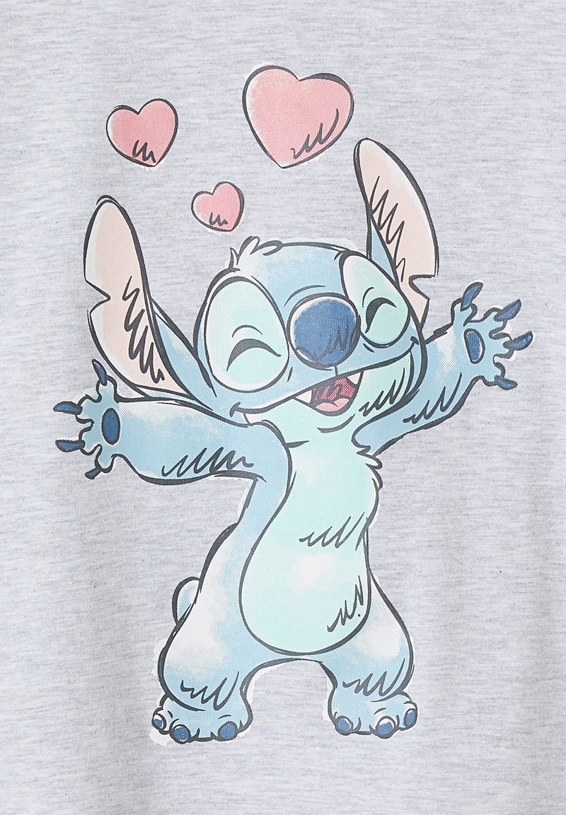 Hellgrau T-Shirt mit einem animierten blauen Charakter mit großen Ohren, der lächelt und die Arme ausstreckt, umgeben von rosa Herzformen.