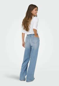 Jeans a gamba larga blu chiaro in denim, con vita alta, due tasche posteriori e una finitura leggermente sbiadita.