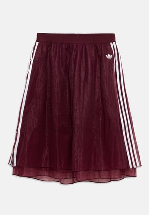Bordeauxrode Adidas-rok met een doorschijnende overlay, elastische tailleband, witte drie-strepen zijpanelen en een wit trefoil-logo op de rechterheup.