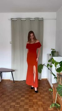 Maxi šaty s červeným gradientom, bez ramienok, s vysokým rozparkom a priliehavým strihom. Hladká textúra látky, skombinované s čiernymi topánkami.