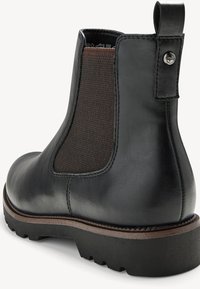 Stivali Chelsea neri in pelle presentano pannelli laterali elastici marroni, una linguetta e una suola in gomma zigrinata con un leggero tacco per una migliore aderenza.