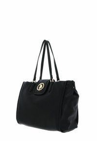 Sac à main en cuir noir avec deux longues anses, un emblème doré sur un rabat pliant, et une forme structurée. Texture lisse, design minimaliste.