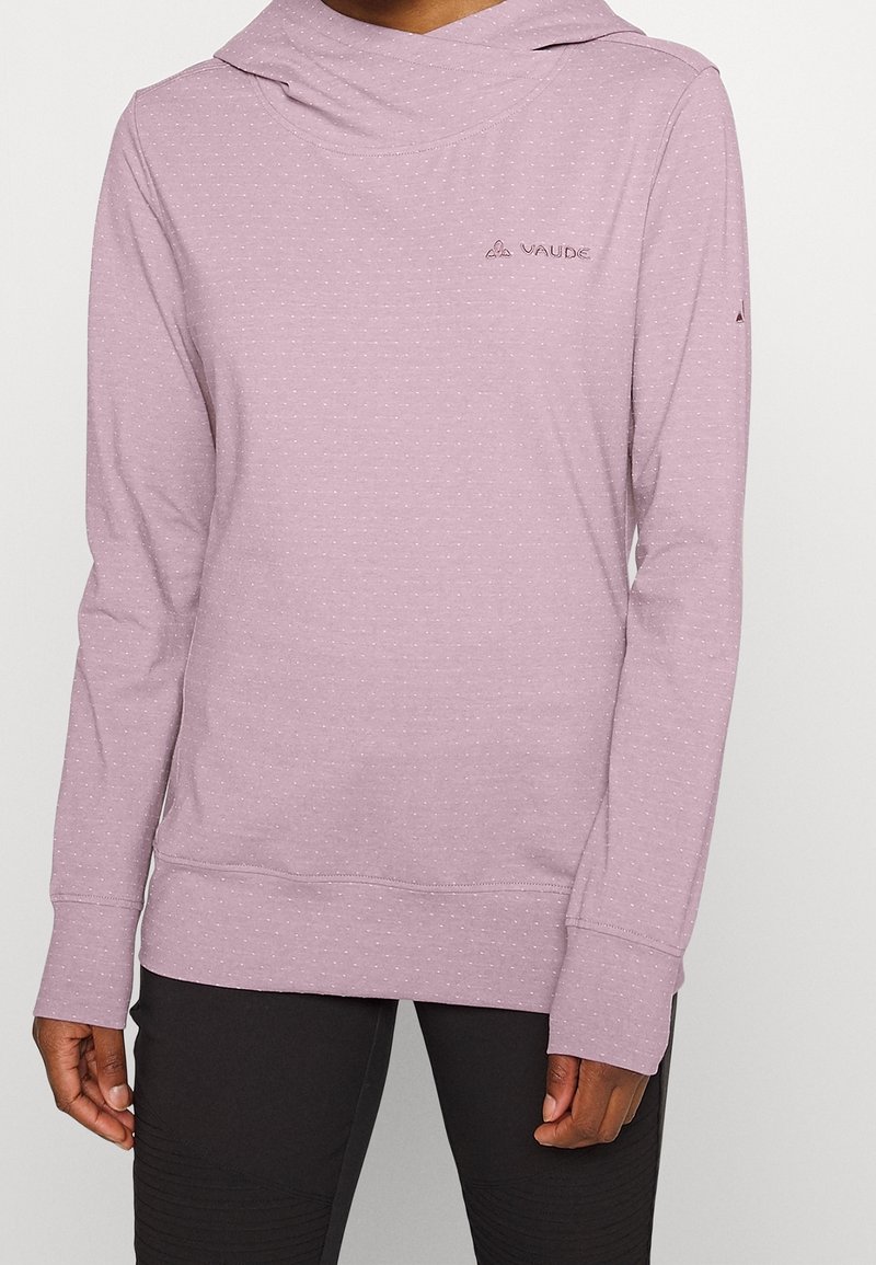 Světle fialová mikina s kapucí vyrobená z měkké látky, s volným límcem, dlouhými rukávy a malými bílými puntíky. Logo VAUDE na levé horní straně.