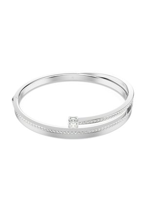 Srebrna bransoletka typu bangle z rzędem małych, przezroczystych kamieni szlachetnych i jednym większym, centralnym kamieniem w minimalistycznym, nowoczesnym stylu.