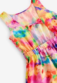 Vestido sin mangas multicolor en tejido transparente, con un estampado floral, cintura fruncida y un pequeño lazo decorativo en el escote.