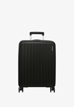 Valigia rigida nera con scanalature verticali, manico telescopico argentato e quattro ruote girevoli per la mobilità. Presenta un accento con marchio.