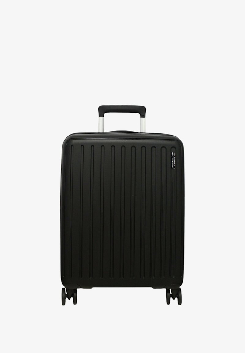 Valise rigide noire avec des rainures verticales, poignée télescopique argentée et quatre roulettes multidirectionnelles pour une meilleure mobilité. Présente un accent de marque.