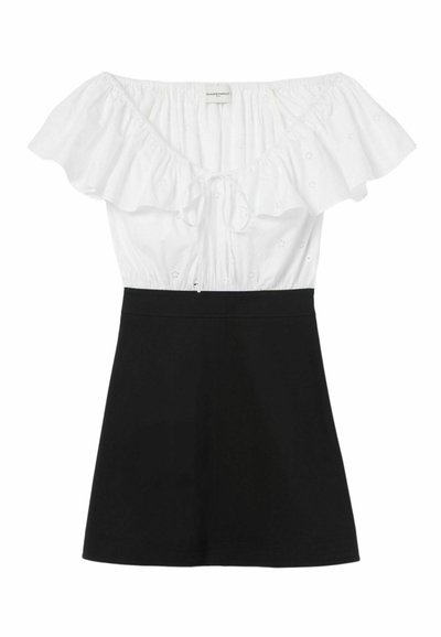 Haut décolleté avec un corsage en coton blanc orné de volants et de motifs à œillets ; jupe noire ajustée.