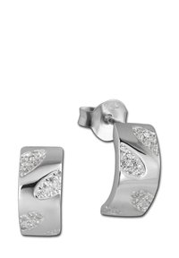 Boucles d'oreilles en argent en forme de créoles avec une surface lisse et des pierres étincelantes intégrées dans des motifs ondulés. Marquées "925" pour l'argent sterling.