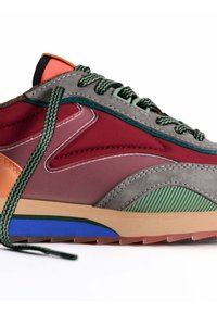 Zapatillas multicolores que presentan una mezcla de materiales en rojo, gris, verde y naranja. Tienen superposiciones texturizadas, acentos con patrones y lazadas verdes.