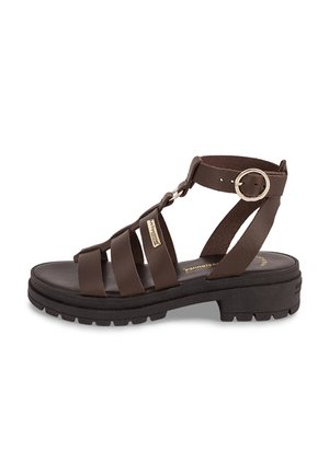 Bruine leren sandaal met meerdere bandjes, een gesp sluiting en een dikke zwarte zool. Voorzien van een textuurzool en metalen merkaccenten.