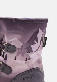 Botki do połowy łydki z purpurowym geometrycznym wzorem, szarymi skórzanymi akcentami, metalowymi oczkami i wzmocnioną podeszwą. Zawierają branding GORE-TEX.