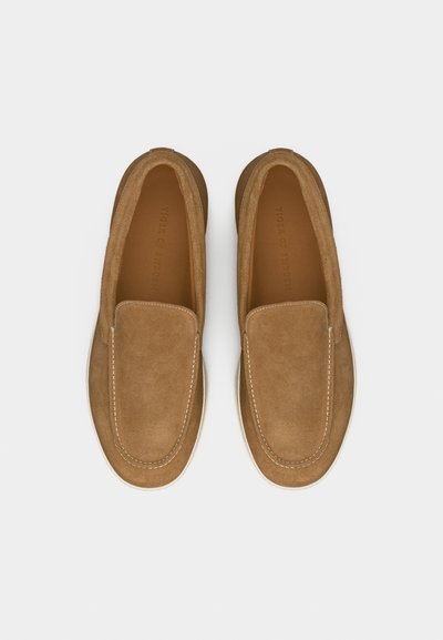Paire de mocassins en daim camel à enfiler avec coutures blanches et semelles en caoutchouc, vue de dessus sur un fond clair.