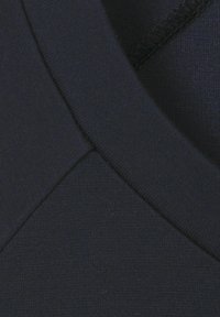 Navyblauwe stof heeft een gladde textuur met een v-vormige halslijn en gestikte randen, wat het aansluitende ontwerp benadrukt.