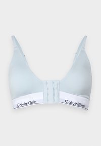 Svetlo modra brezžična modrčka z gladko teksturo, nastavljivimi naramnicami in belo elastiko s logotipom "Calvin Klein". Zapenjanje z zankico in očesom na hrbtni strani.