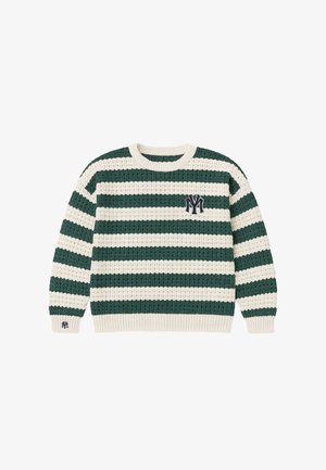 Man draagt een groen-wit gestreepte gebreide trui met een embleem, krijtstreeppantalon en een beige truckerpet met een logo.