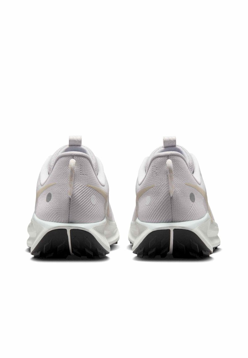 Zapatillas de running blancas con parte superior de tela texturizada, acentos en gris claro, una etiqueta de tirón en el talón y suela de goma negra con surcos de tracción.
