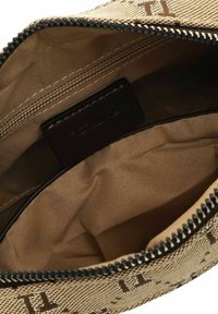 Beige gefütterte Tasche mit Reißverschluss. Das Innere verfügt über eine glatte Stoffauskleidung und ein kleines Markenzeichen. Sauberes Design, schlichte Struktur.