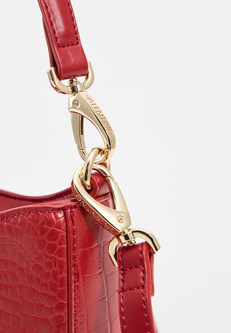 Borsa a tracolla in pelle rossa con finitura testurizzata, dotata di una chiusura in metallo dorato e attacco per la tracolla, che mette in risalto i dettagli hardware di qualità.