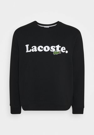 Schwarzer Sweatshirt mit langen Ärmeln und weißem "Lacoste."-Schriftzug sowie einem kleinen grünen Krokodil-Logo auf der Brust.