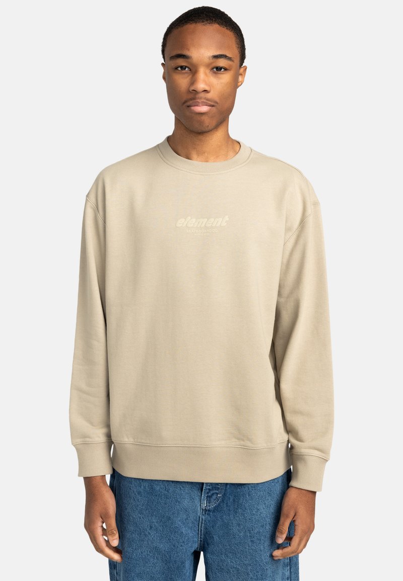 Beige bomulls sweatshirt med rund halsringning, lös passform och ribbade ärmmuddar. Har en subtilt tryckt "element"-logotyp. Bärs tillsammans med blå jeans.