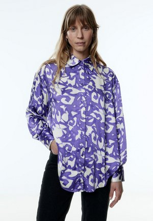 Paarse en witte gestreepte blouse met een relaxed fit, knoopsluiting, en lange mouwen, gemaakt van zachte stof.