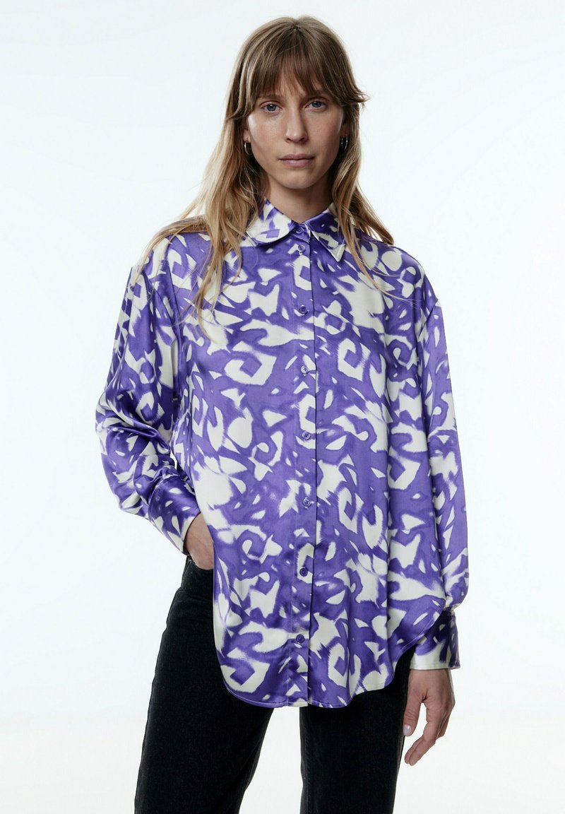 Paarse en witte gestreepte blouse met een relaxed fit, knoopsluiting, en lange mouwen, gemaakt van zachte stof.