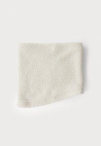Fehér, texturált szövet, amely puha, bolyhos megjelenésű. Szabálytalan, enyhén ferde alak. Nincsenek látható varratok vagy minták.