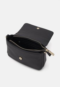 Black leather bag with a textured finish, gold hardware, and a zip closure. Interior features multiple compartments for organization.