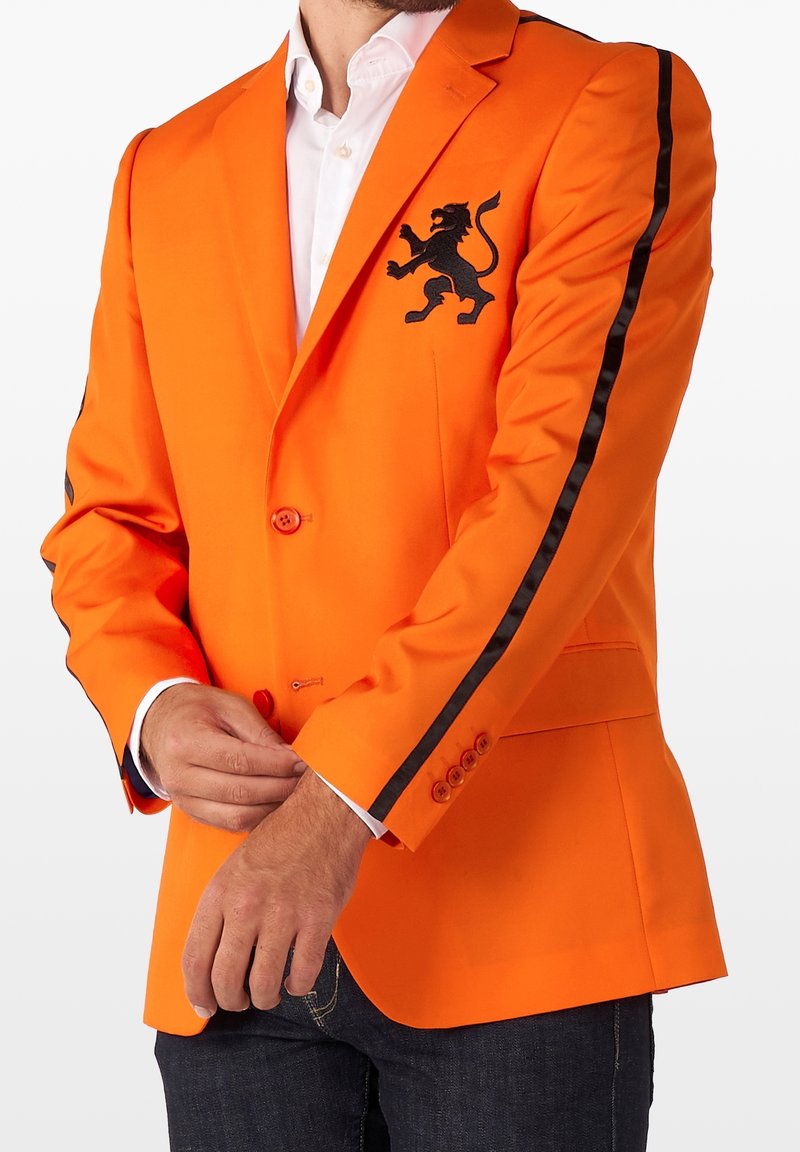 Pomarańczowy żakiet z czarnym haftem lwa na klatce piersiowej, kontrastowe czarne paski wzdłuż rękawów oraz gładka faktura materiału.