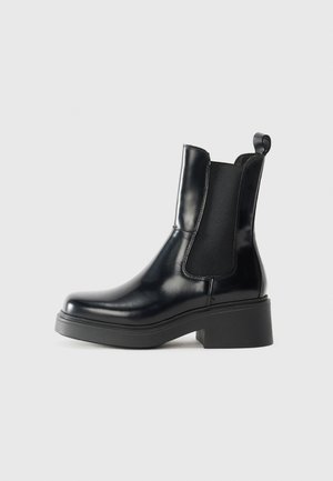 Stivaletto Chelsea in pelle nera con pannelli laterali elastici, punta rotonda e tacco spesso nero. Texture liscia con un pratico pull tab sul retro.
