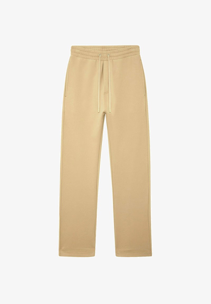 Pantalons de survêtement beige à cordon de serrage avec taille élastique et poches latérales, design à jambes droites, posés à plat sur un fond blanc.