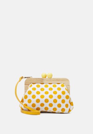 Mała kopertówka z drewnianą ramką, żółtymi kropkami na białej tkaninie, żółtymi kulistymi zapięciami oraz odpinanym żółtym paskiem na nadgarstek.