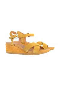 Sandali con zeppa in suede giallo, caratterizzati da molteplici cinghie incrociate, fibbia regolabile alla caviglia e una suola intermedia in fibra tessuta. Suola esterna in gomma liscia.