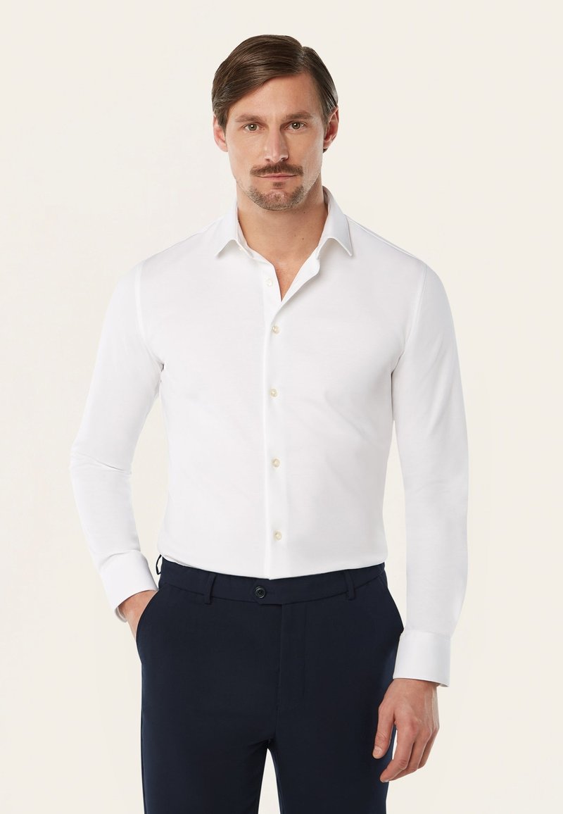 Witte lange mouwen shirt met een gespreide kraag, knoopsluiting en gouden knopen. Glad materiaal met een getailleerde pasvorm, gecombineerd met donkere broek.