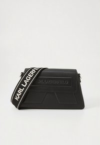 Čierna kožená kabelka so štruktúrovaným dizajnom, s textúrovanou prednou časťou, vyrazeným logom a kontrastným tkaným remienkom s nápisom "KARL LAGERFELD."