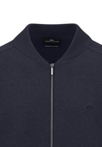 Navy katoenen zip-up jack met een geribbelde kraag en subtiel logo op de borst. Kenmerkt zich door een gladde textuur en een getailleerd ontwerp.
