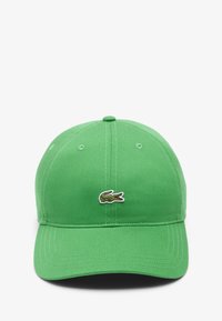 Gorra de béisbol de algodón verde con visera curva, que presenta un pequeño emblema de cocodrilo bordado en la parte frontal.