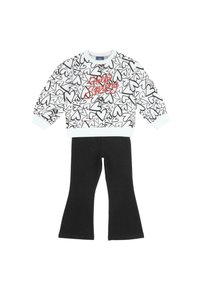 Haut blanc à manches longues avec motifs de cœurs noirs et texte rouge "Hello Spring", associé à un pantalon évasé noir uni.