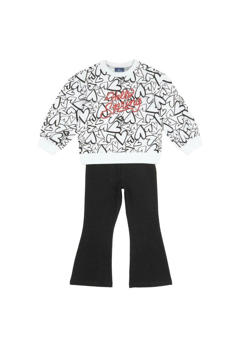 Haut blanc à manches longues avec motifs de cœurs noirs et texte rouge "Hello Spring", associé à un pantalon évasé noir uni.