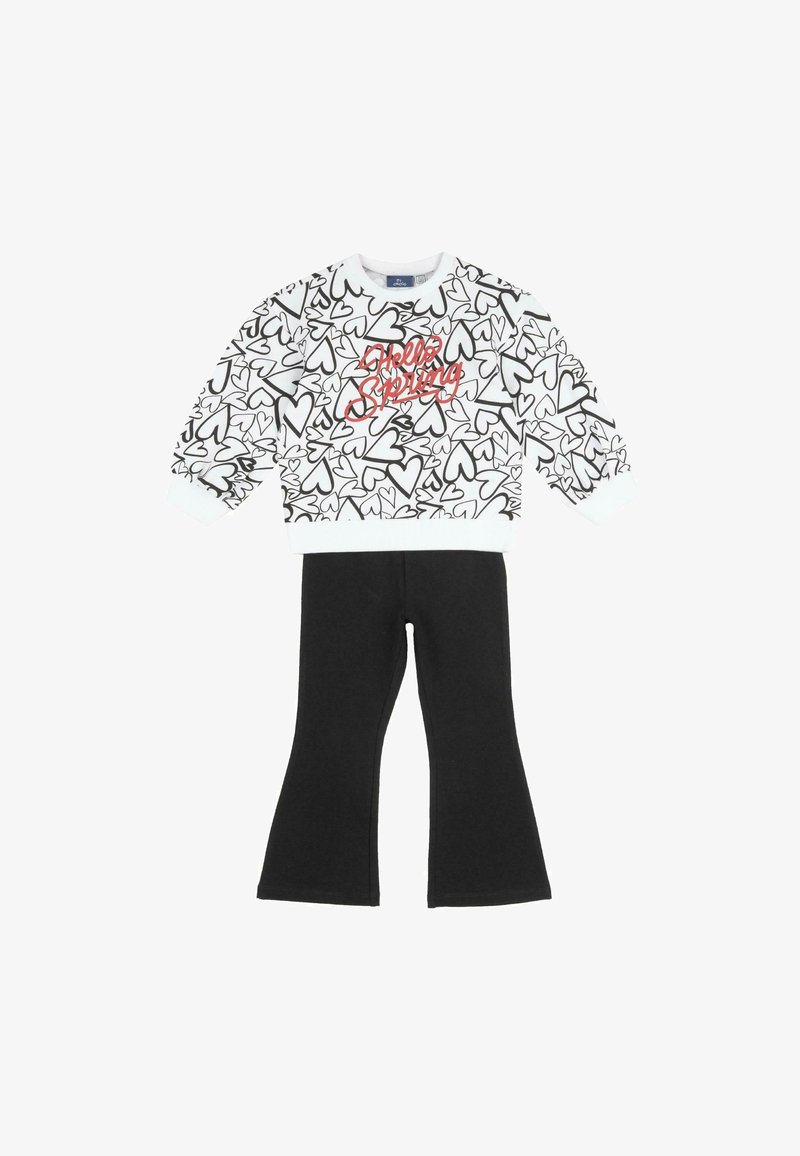 Haut blanc à manches longues avec motifs de cœurs noirs et texte rouge "Hello Spring", associé à un pantalon évasé noir uni.