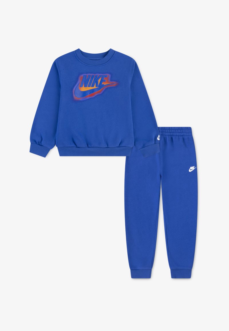 Niebieski zestaw bluz i spodni z miękkiego materiału, z wyraźnym pomarańczowym i żółtym logo Nike z przodu. Elastyczny pas i mankiety.