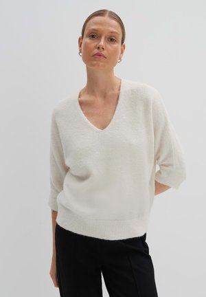 V-Ausschnitt, kurzärmeliger Pullover aus weichweißem Stoff; leicht, entspannter Schnitt mit geripptem Saum und glatter Textur.