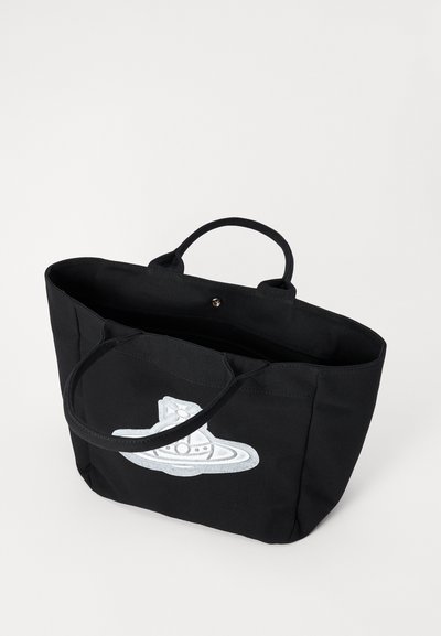 Sort lærred tote taske med rummelig indre og korte håndtag, prydet med et hvidt broderet grafisk design af et rumskib.