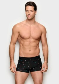 Sorte bokser-shorts med farverige mønstre, herunder små blomster og abstrakte former, lavet af et glat, fleksibelt stof.